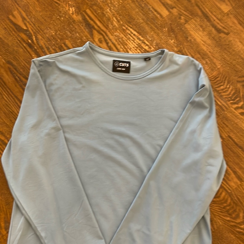 Cuts long sleeve shirts, one black, one blue, both size medium